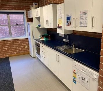 Clean school kitchen with white cabinets