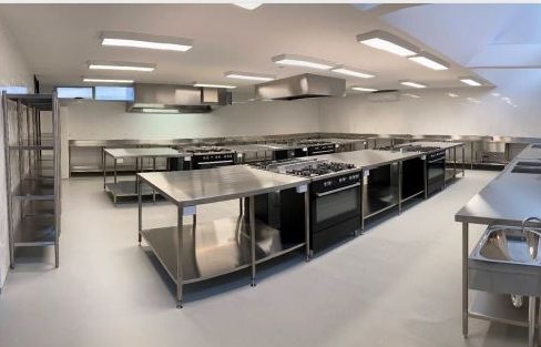 Commercial kitchen with polished stainless steel benches